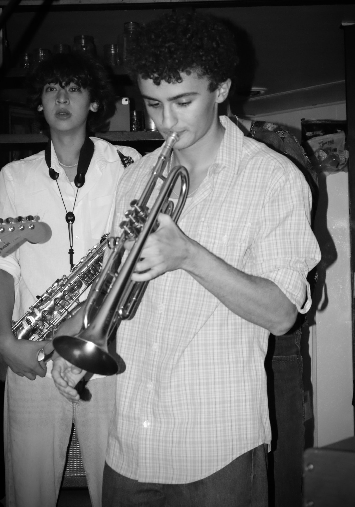 Black and white shot of the trumpet player with the saxophonist behind