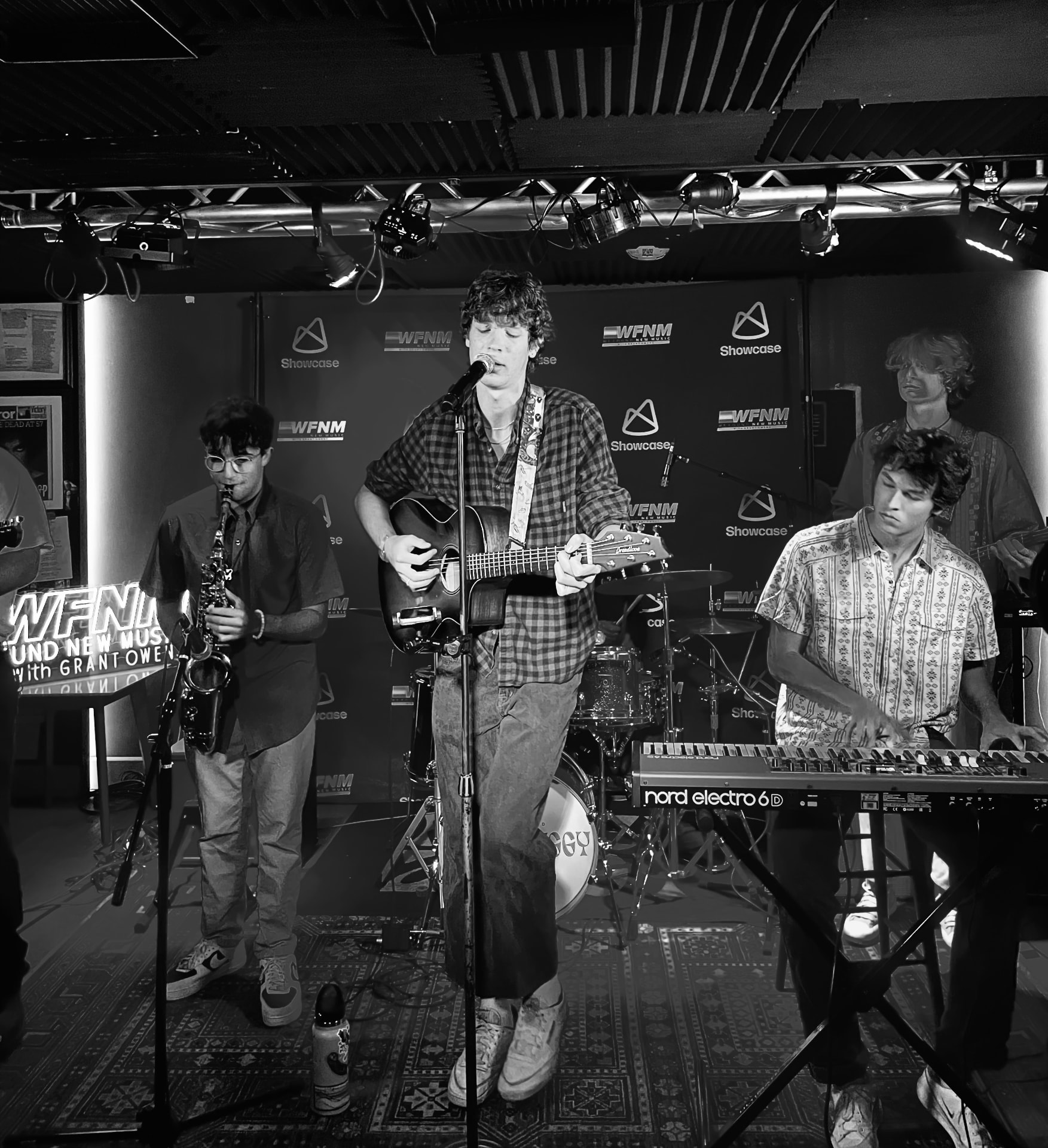 Black and white portrait of the full band on stage at a WFNM showcase
